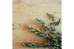 Image Fresh rosemary sprigs on a wooden cutting board